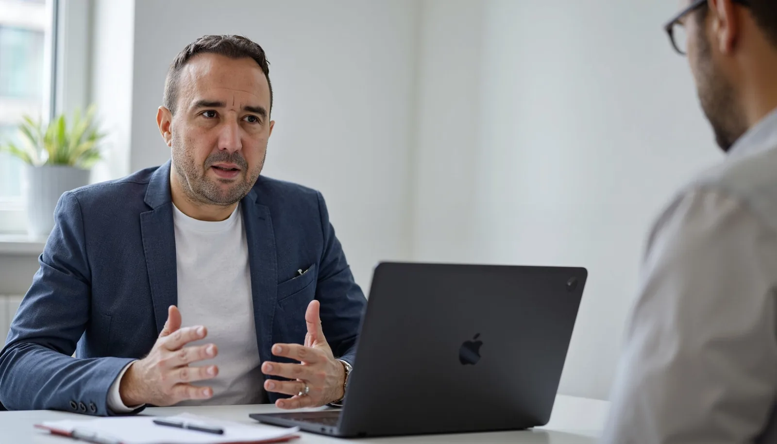 Christian Gottschling erklärt einem Kunden das Exposé am Laptop